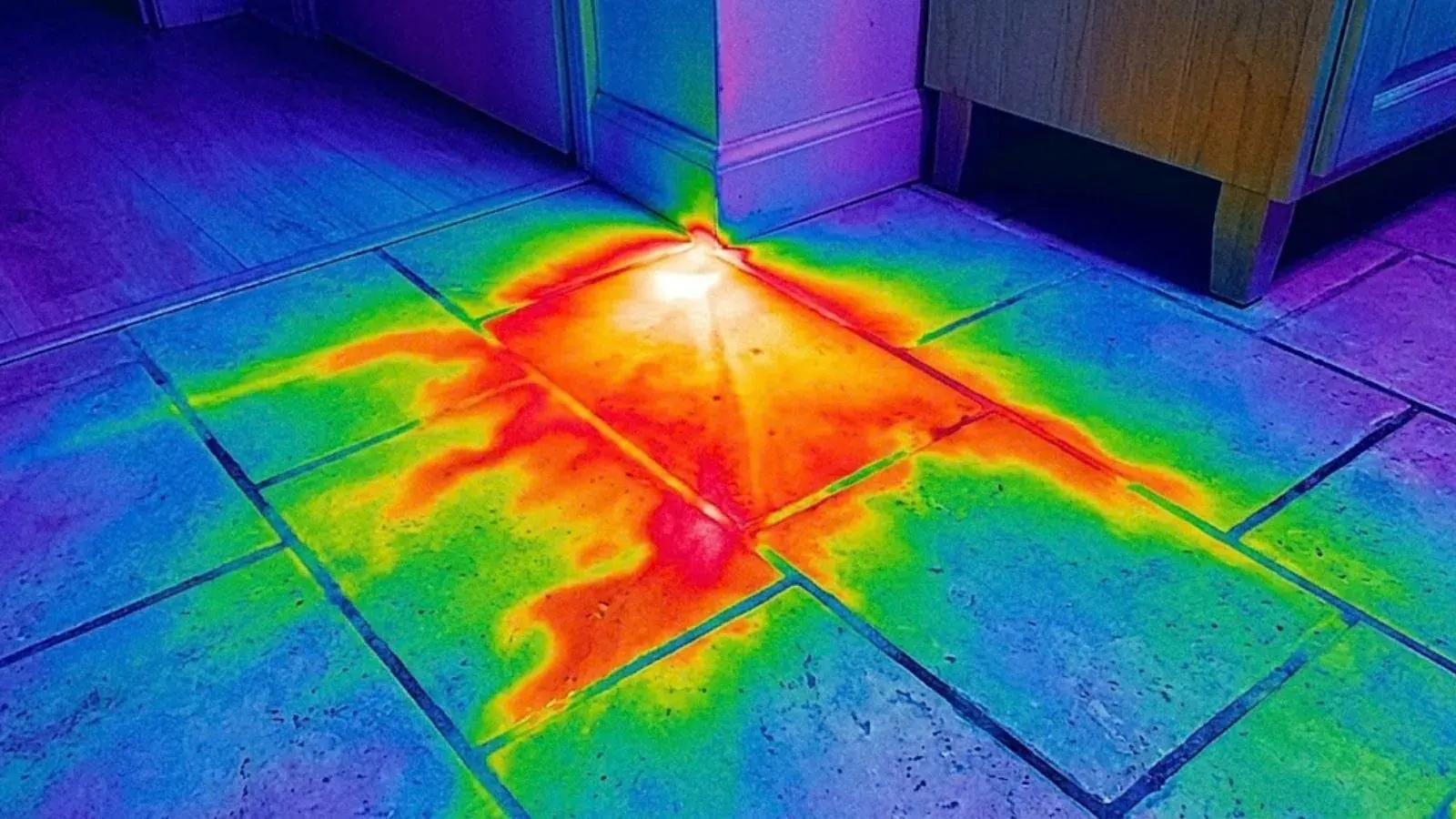 Thermal image of a tile floor showing a warm leak pattern spreading across it